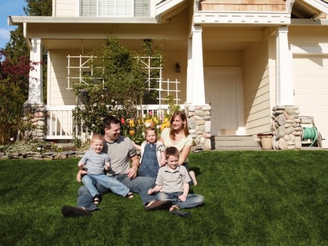 Happy family on front porch after home remodel – Summit Exteriors Satisfaction Guarantee